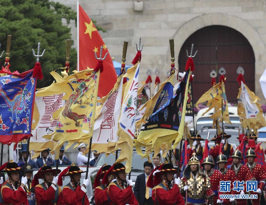 7月3日，韓國總統(tǒng)樸槿惠在青瓦臺總統(tǒng)府舉行隆重儀式，歡迎中國國家主席習近平對韓國進行國事訪問。這是習近平的車隊在身著民族服裝的韓國禮儀隊伍引導下駛入青瓦臺。新華社記者丁林攝  